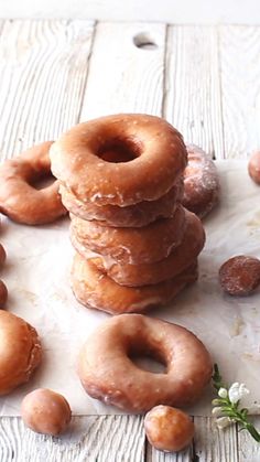 a stack of doughnuts sitting on top of a wooden table next to flowers