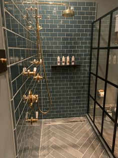 a bathroom with blue tiled walls and flooring is shown in this image, there are two shower heads on the wall