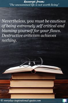 an open book sitting on top of a pile of books next to a blackboard