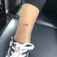 a woman with a small tattoo on her leg that reads,'909 '