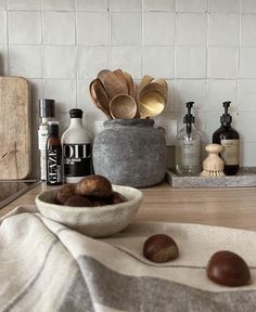 a bowl filled with nuts sitting on top of a counter next to bottles and spoons