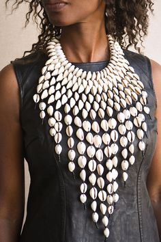 This Statement Cowrie Shell Necklace is crafted with Authentic Cowrie Shell Beads for a unique and beautiful look.It is a unique piece of African Tribal Jewelry, sure to make a statement. Handmade with love, this is the perfect accessory for any wardrobe.  Length: 18" Elegant Beaded Necklace With Wooden Beads, Beaded Costume Jewelry Necklaces, Elegant Necklaces With Wooden Beads, Elegant Wooden Beads Necklace, Artisan Beaded Necklace With Black Beads, Artisan Style Beaded Chain Necklace, Unique White Necklaces With Wooden Beads, Multi-strand Necklaces With Large Beads, White Bohemian Necklace With Black Beads