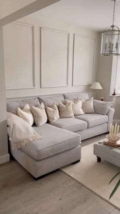 a living room filled with furniture and a large white couch in front of a window