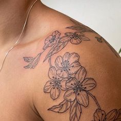 a close up of a person's shoulder with flowers on it