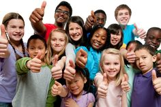 a group of children giving thumbs up in front of the camera with their hands together