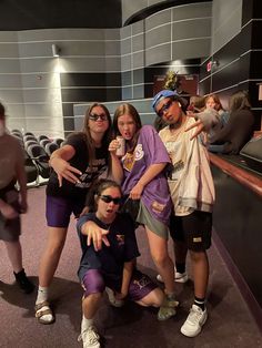 some people are posing for a photo in the middle of a room with purple carpet