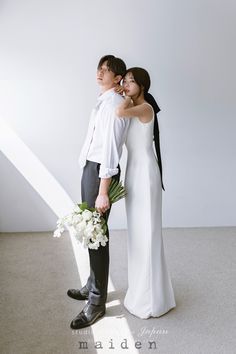 a man and woman standing next to each other holding bouquets in their hands,