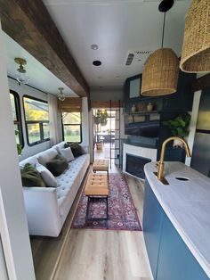 a living room filled with furniture next to a kitchen and dining area in a mobile home