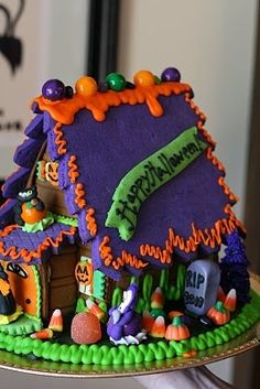 a decorated halloween house on a cake plate