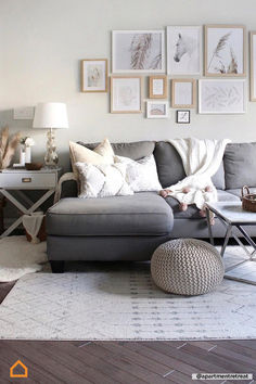 a living room with gray couches and pictures on the wall above them, along with a coffee table