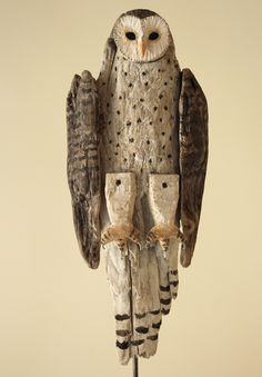 an owl statue sitting on top of a wooden stand