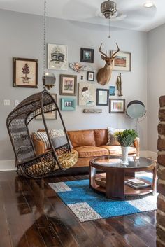 a living room filled with furniture and pictures hanging on the wall behind a swing chair