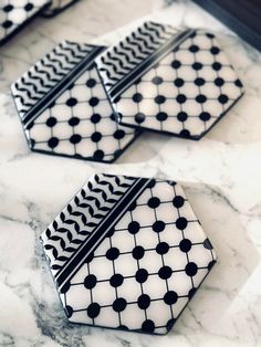 three black and white tiles sitting on top of a marble counter