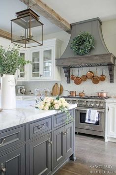 a kitchen with an oven, range and potted plants on the counter top in front of it