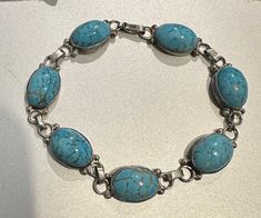 "7\" sterling silver bracelet. This beautiful bracelet has 7 oval turquoise stones set in sterling silver. The back of the bracelet is marked \"Hecho en Mexico DF 925\" around initials. The bracelet is in good condition with very little tarnish, but one of the dividing links is worn. The clasp is a hook which holds securely. Please message with any questions." Elegant Turquoise Oval Sterling Silver Bracelet, Adjustable Oval Turquoise Sterling Silver Bracelet, Handmade Turquoise Sterling Silver Oval Bracelet, Handmade Turquoise Oval Sterling Silver Bracelet, Sterling Silver Turquoise Oval Bracelet Gift, Handmade Oval Turquoise Sterling Silver Bracelet, Hook Bracelet, Hammered Sterling Silver, Gold Wash