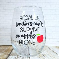 a clear wine glass with an apple on the side and words written in black ink