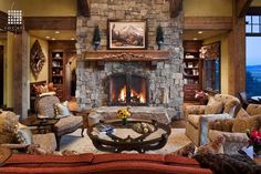 a living room filled with lots of furniture and a fire place in the middle of it