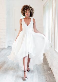 a woman in a white dress is posing for the camera