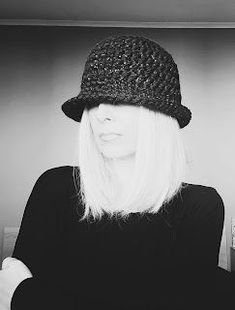 black and white photograph of a woman with long hair wearing a crocheted hat