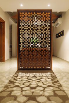 a room divider in the middle of a floor with circles on it and a potted plant behind it