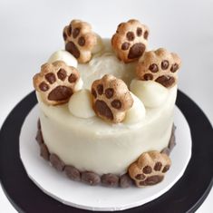 a cake with white frosting and chocolate chips on top, decorated with animal paw prints