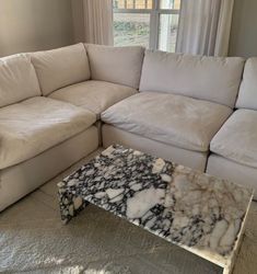 a marble coffee table sitting in front of a white couch