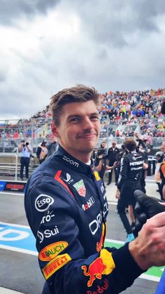 a man in a red bull racing suit shaking hands