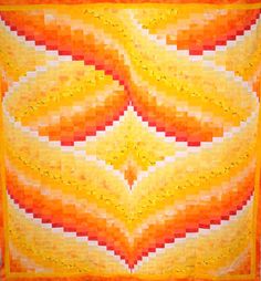 an orange and yellow quilt on display