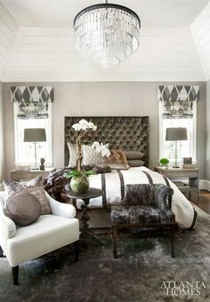 a bedroom with a bed, chair and chandelier