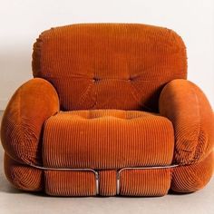 an orange chair sitting on top of a cement floor