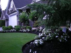 a house with white flowers in the front yard