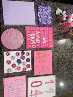 some pink and purple items are on the counter next to each other, including greeting cards