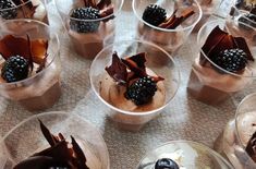 desserts in plastic cups with blackberries on top