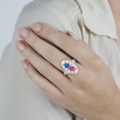 This is part of Chairish’s Fine Jewelry assortment.  This ring showcases a captivating interplay of color and light. A mesmerizing oval sapphire, boasting 0.48 carats, shimmers with a blue hue. Its brilliance is complemented by a fiery counterpart: an oval ruby radiating 0.33 carats of deep pink. 14 European-cut round diamonds, meticulously set, add a touch of elegance. Crafted from platinum, this ring offers both durability and sophisticated style.  All the gemstones are natural and the ring is Fusion Style Oval Birthstone Rings, Multicolor Oval Ruby Ring For Gift, Multicolor Oval Ruby Ring Gift, Oval Birthstone Fusion Rings, Fusion Style Oval Ring For Anniversary, Fusion Oval Multi-stone Rings, Fusion Style Oval Multi-stone Rings, Multicolor Oval Fusion Rings, Fusion Style Oval Rings With Polished Finish