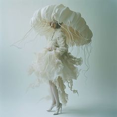 a woman in a white dress holding an umbrella