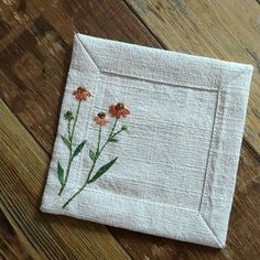 an embroidered piece of cloth with flowers on it