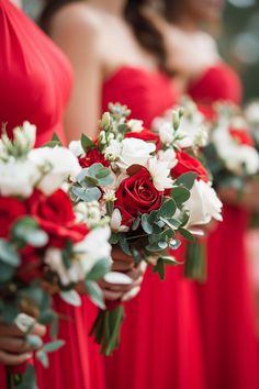 bridesmaids in red dresses holding bouquets with white and red flowers