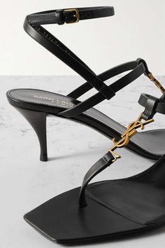 SAINT LAURENT Cassandra embellished leather sandals | NET-A-PORTER Luxury Gold T-strap Sandals, Luxury T-strap Sandals With Heel And Single Toe Strap, Gold Luxury Open Toe T-strap Sandals, Gold Open Toe Luxury T-strap Sandals, Luxury Gold T-strap Open Toe Sandals, Luxury Gold T-strap Sandals With Open Toe, Designer T-strap Sandals For Evening, Luxury Evening T-strap Sandals With Single Toe Strap, Luxury T-strap Sandals With Single Toe Strap For Evening