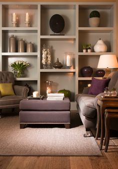 a living room filled with furniture and bookshelves on top of eachother