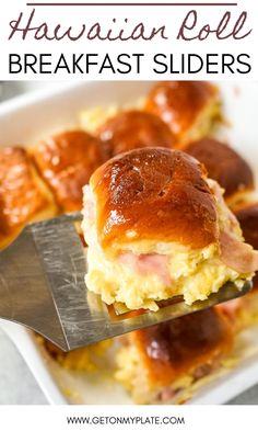 ham and cheese roll breakfast sliders on a white plate with a serving spatula