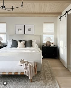 a bedroom with white walls and wood floors