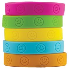 four different colored bracelets with smiley faces on each one and an emoticive face on the other