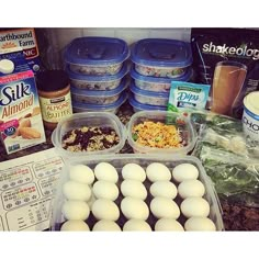 an assortment of eggs and other food items on a kitchen counter with milk, butter, yogurt, cereal, and more