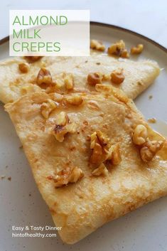 two pieces of food sitting on top of a white plate with walnuts and milk