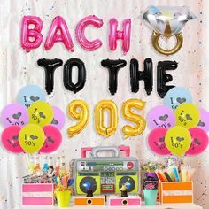 a party with balloons and streamers that read, back to the 90's