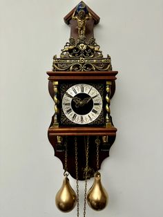 an antique clock with bells hanging from it's sides