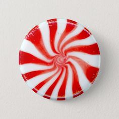 a red and white peppermink candy button on a white background with room for text