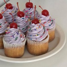 cupcakes with white frosting and sprinkles on a plate