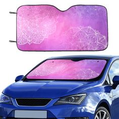 a blue car with pink and white flowers on it's front windshield window cover