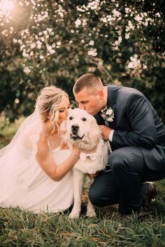 a bride and groom pose with their dog